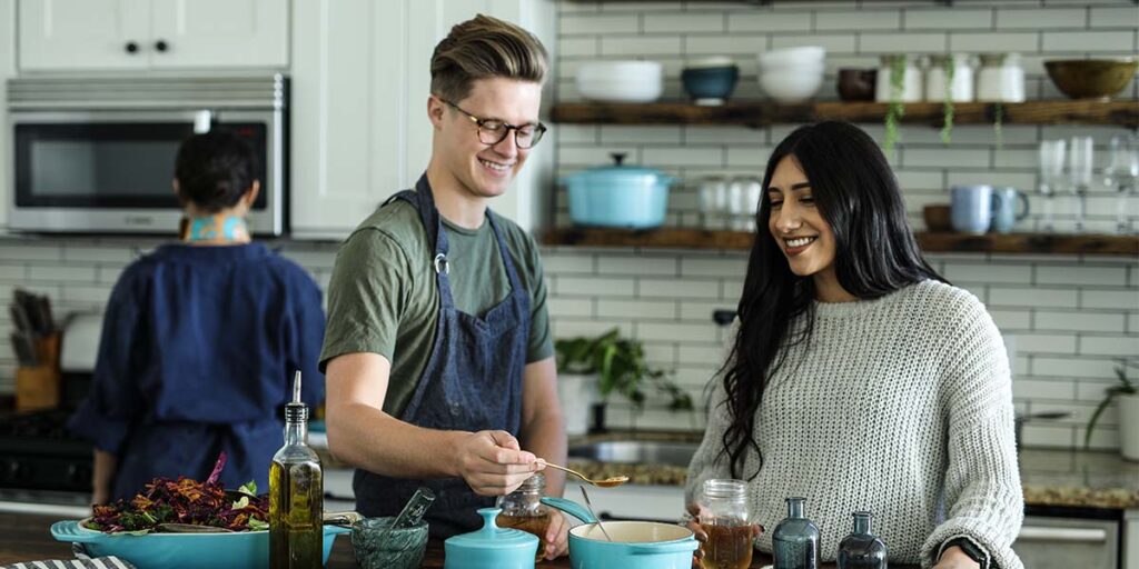 A catering image, featuring two young chefs preparing food in a kitchen.