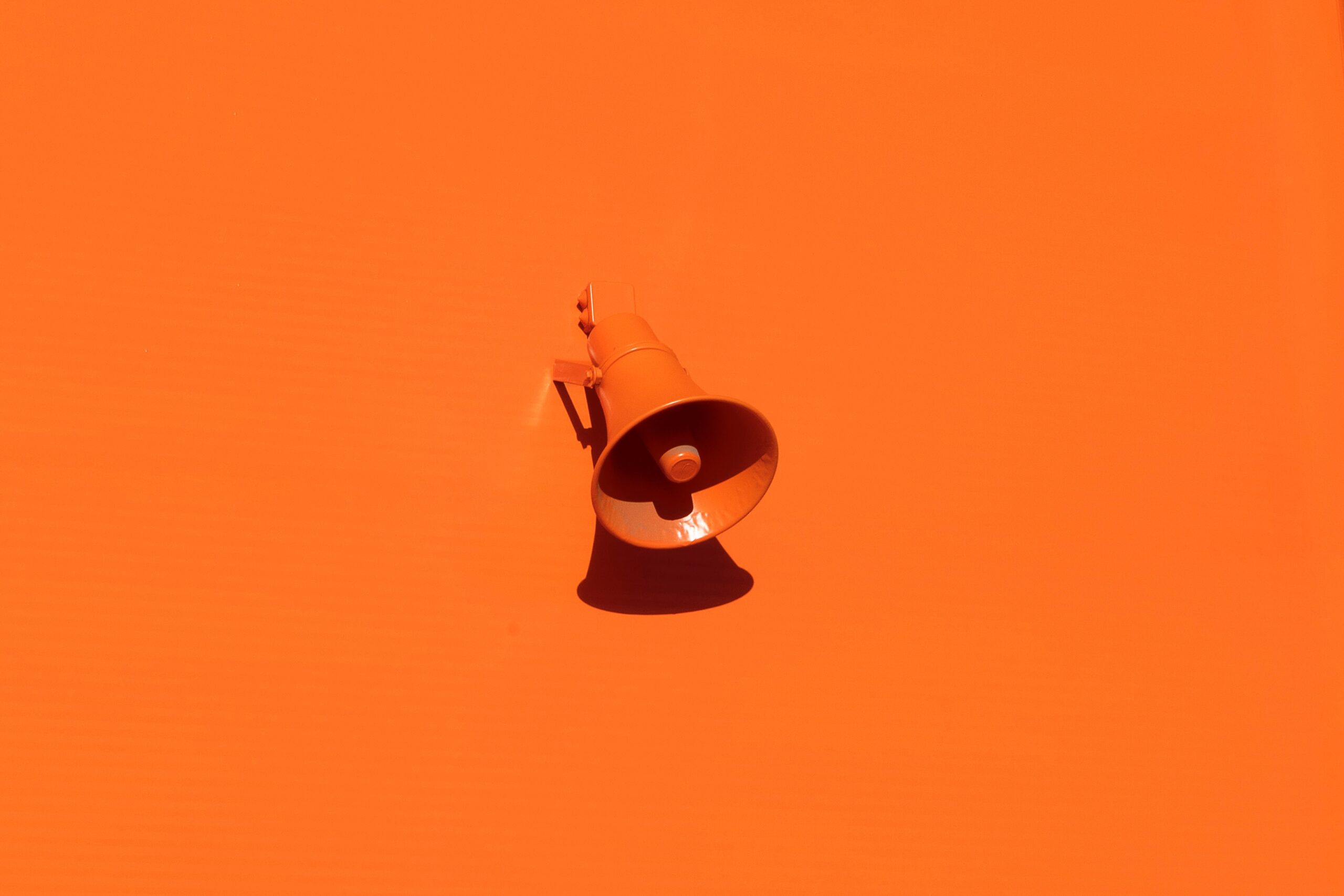 Orange megaphone on orange background for tone of voice guidelines article