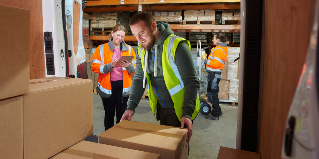 Delivery workers in a warehouse wearing hi vis 