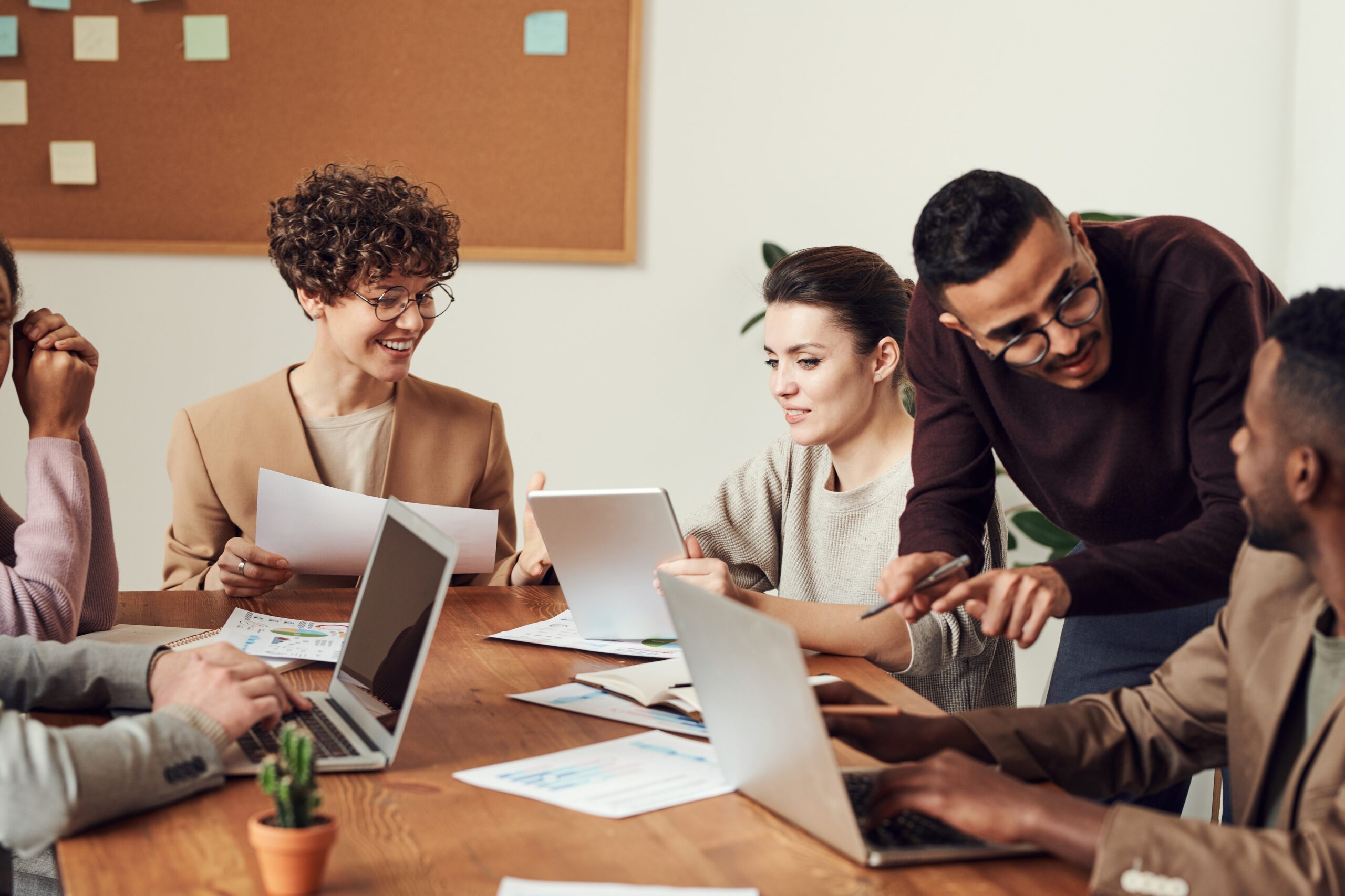 A team of males and females working on their Degree Apprenticeship together on a table