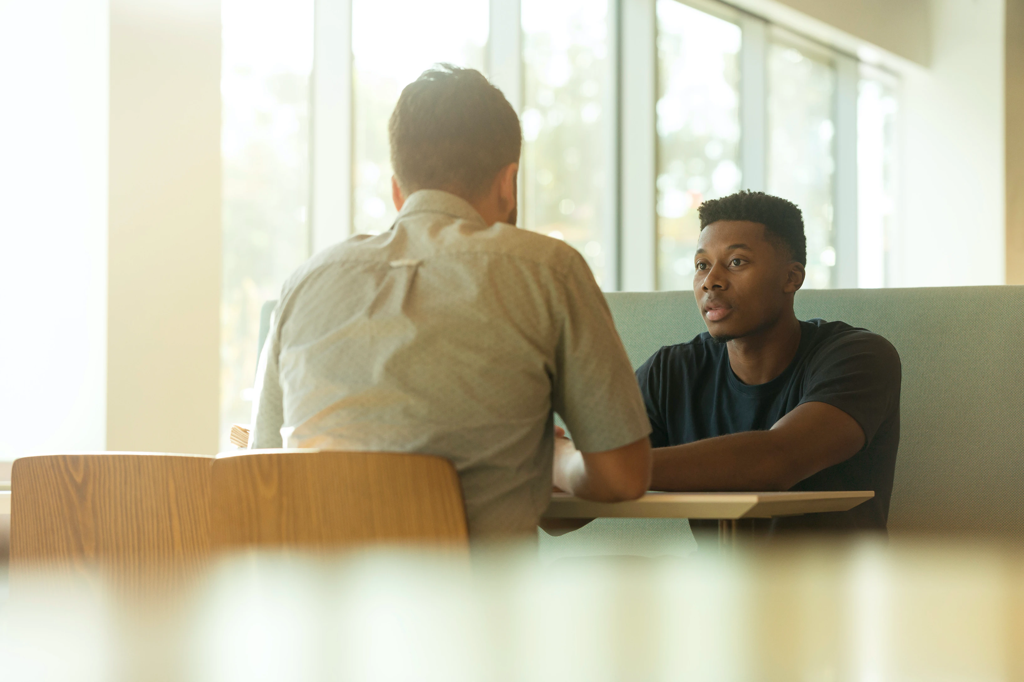 Career mentoring showing two people talking at a table in an office