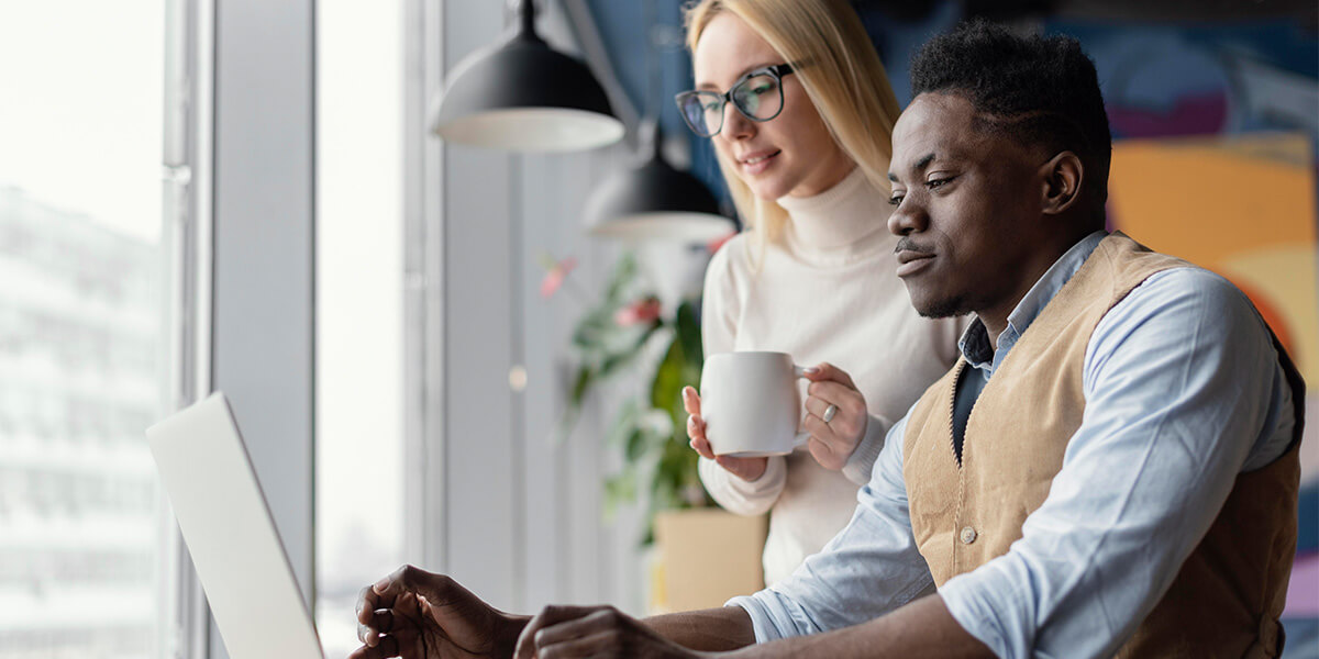 Coworkers working on laptop in office