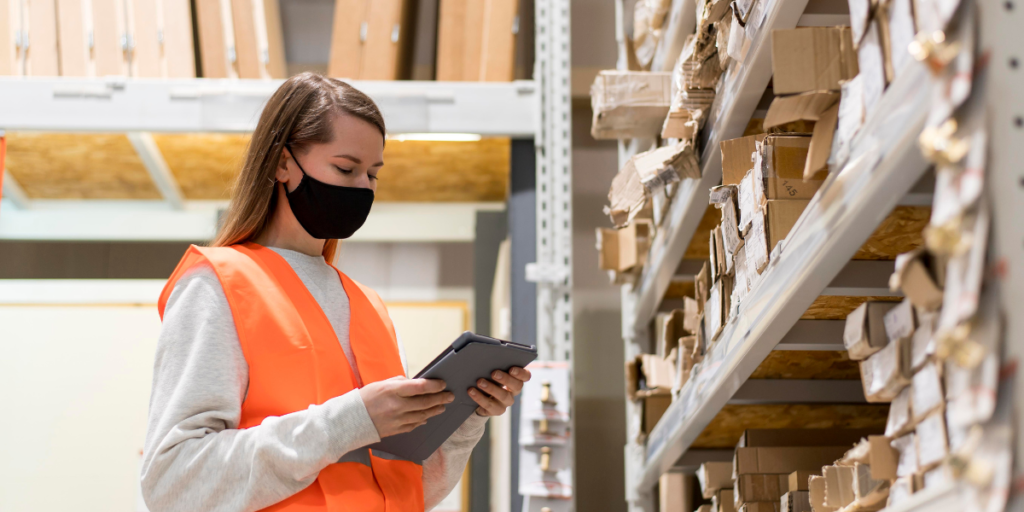 Picture of woman in a mask working in a warehouse.